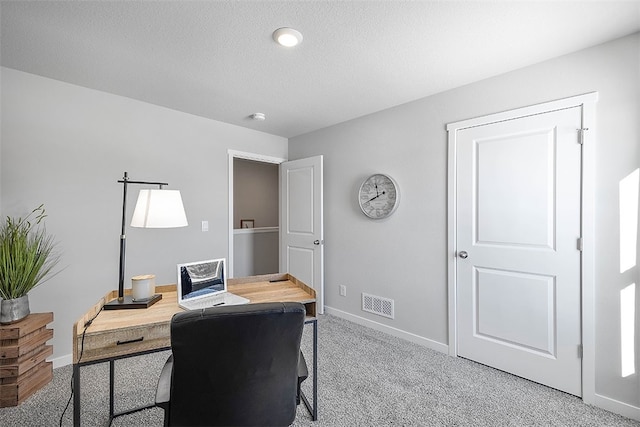 carpeted office space with a textured ceiling