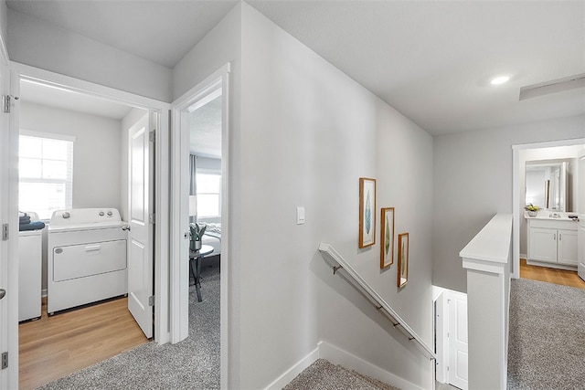 stairs with hardwood / wood-style flooring and washing machine and dryer