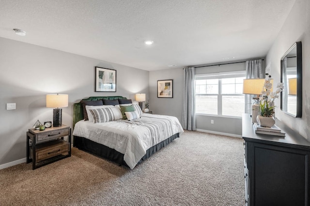 bedroom featuring light carpet, a textured ceiling, and baseboards