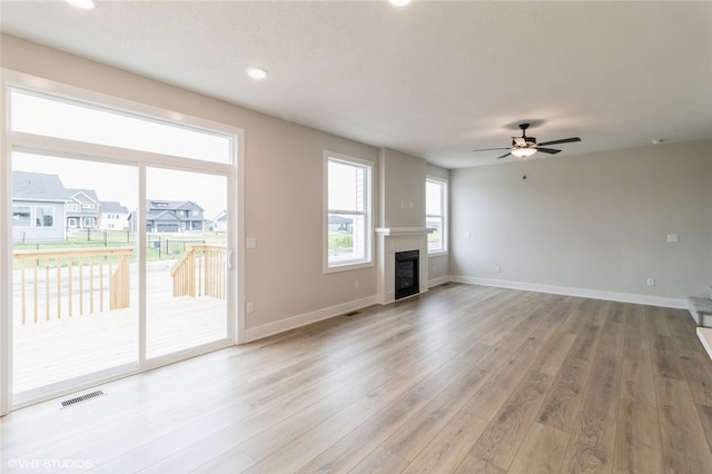 unfurnished living room with ceiling fan and hardwood / wood-style floors