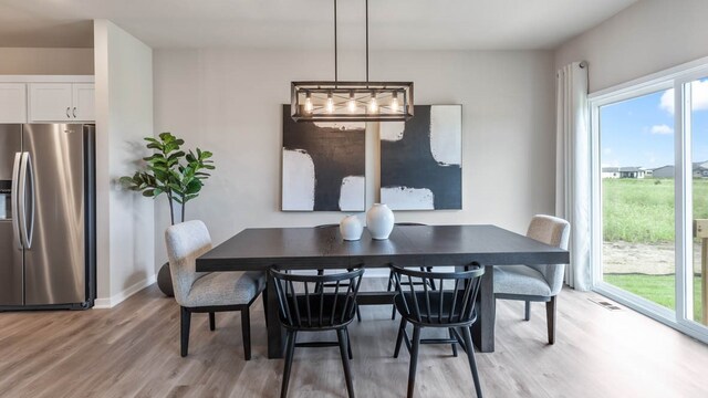 dining area with a wealth of natural light and light hardwood / wood-style flooring