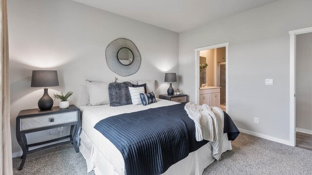 bedroom featuring ensuite bathroom and dark colored carpet