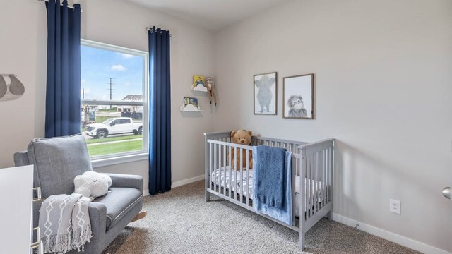 carpeted bedroom with a nursery area