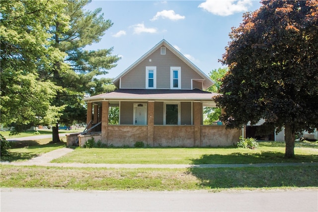 country-style home with covered porch and a front lawn