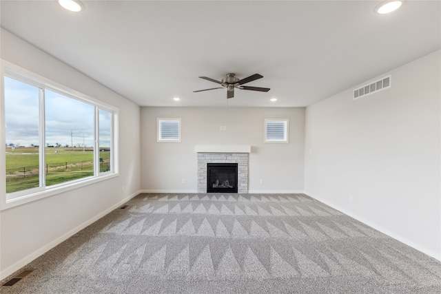 unfurnished living room with light carpet, a fireplace, and ceiling fan