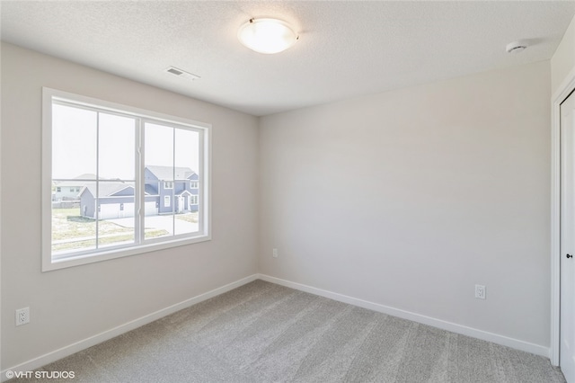 unfurnished room with carpet floors and a textured ceiling