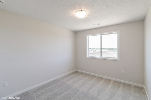 carpeted spare room featuring a textured ceiling