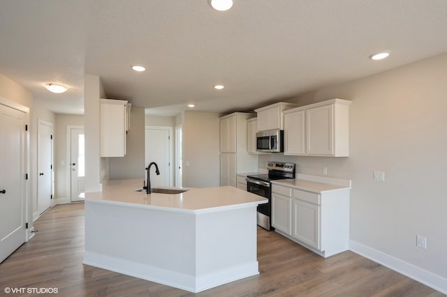 kitchen with white cabinetry, stainless steel appliances, sink, and light wood-type flooring