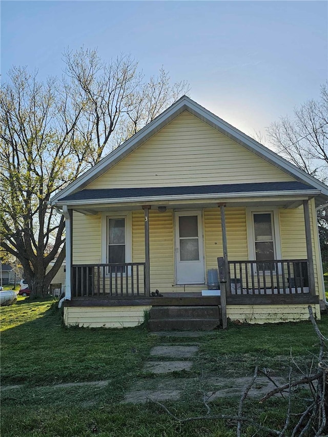 bungalow-style home featuring a porch and a front yard