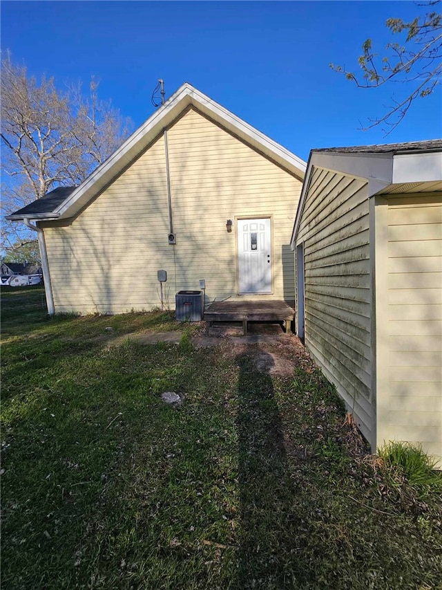 view of side of property with a yard and central AC