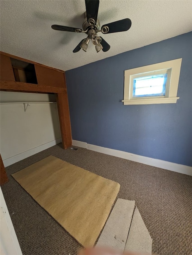 carpeted spare room featuring a textured ceiling and ceiling fan