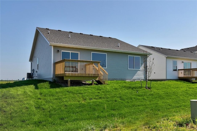 rear view of house with a lawn, a deck, and central AC