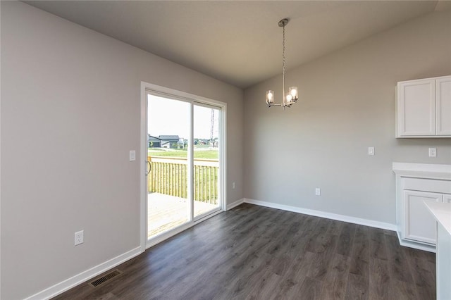 unfurnished dining area with dark hardwood / wood-style floors, vaulted ceiling, and an inviting chandelier