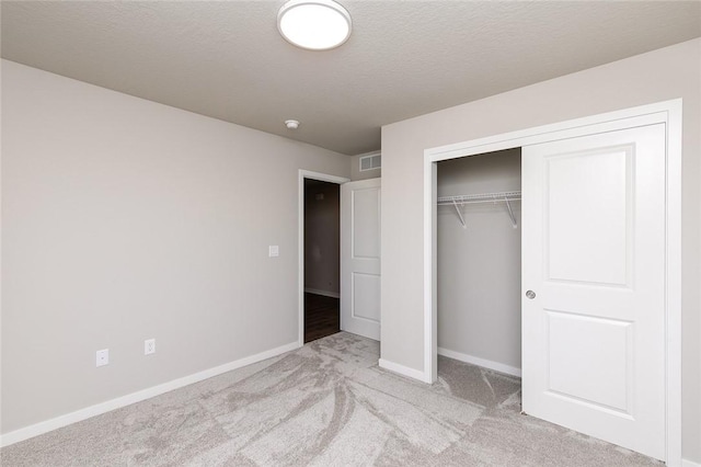 unfurnished bedroom featuring light carpet and a closet