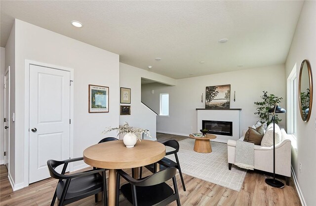 dining area featuring light hardwood / wood-style floors and a textured ceiling