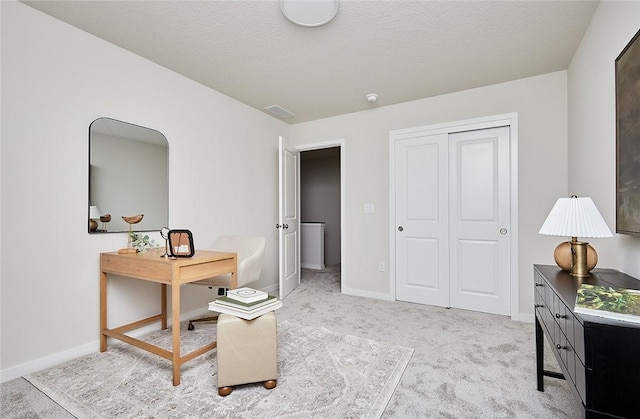 office featuring a textured ceiling and light carpet