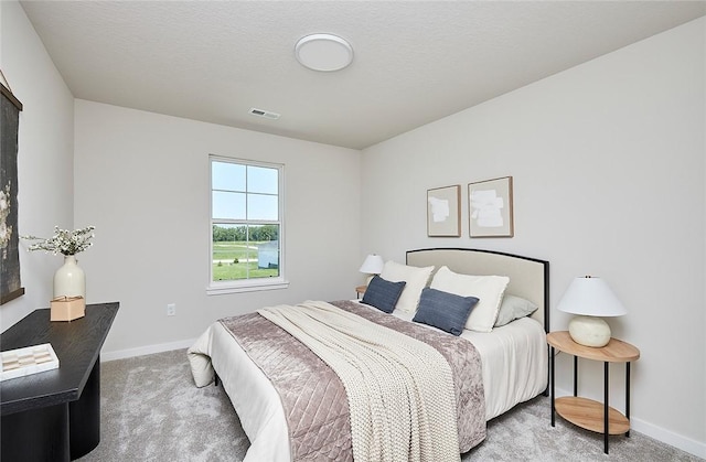 carpeted bedroom with a textured ceiling