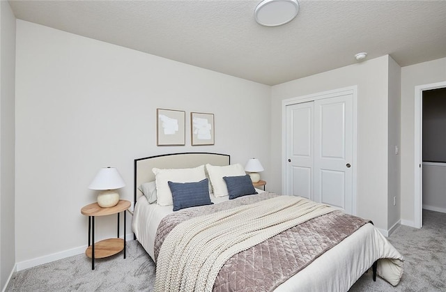 bedroom featuring a textured ceiling, light carpet, and a closet