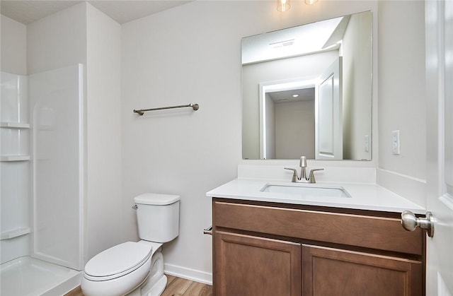 bathroom featuring a shower, vanity, toilet, and hardwood / wood-style floors