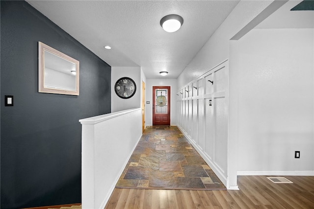 corridor with tile flooring and a textured ceiling