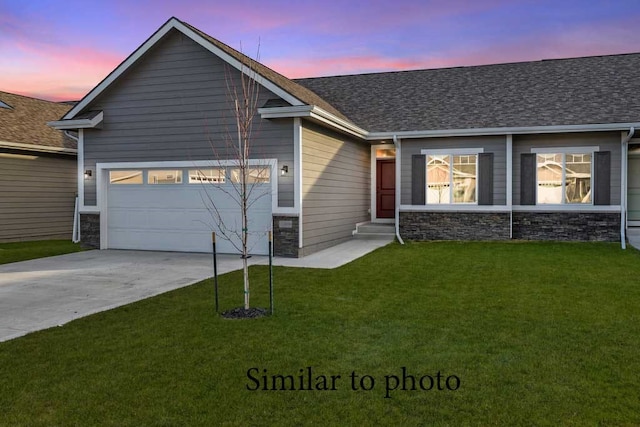 view of front of home with a garage and a lawn