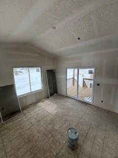 spare room featuring lofted ceiling and a textured ceiling