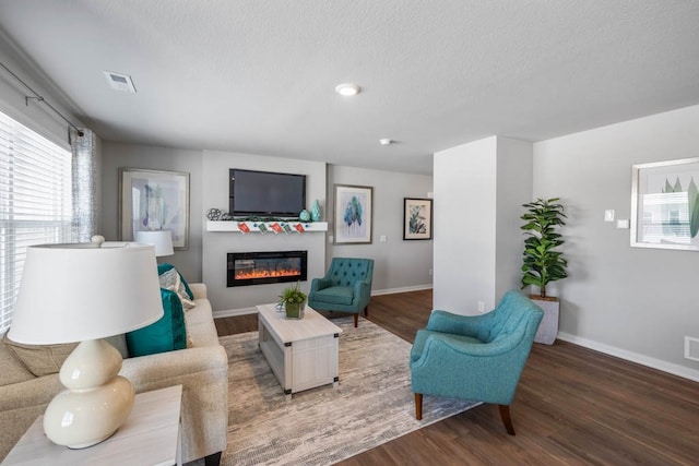 living room with a textured ceiling and dark wood-type flooring