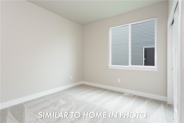 carpeted empty room with visible vents and baseboards