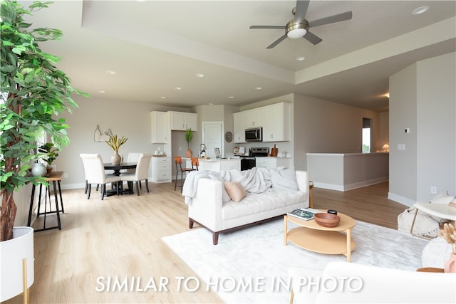 living area featuring recessed lighting, light wood-type flooring, a ceiling fan, and baseboards