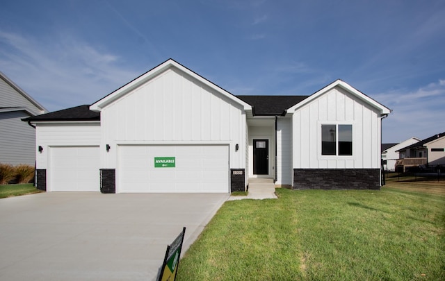 modern farmhouse featuring board and batten siding, a front yard, concrete driveway, and a garage