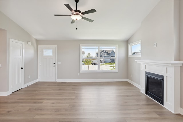 unfurnished living room featuring light hardwood / wood-style floors, vaulted ceiling, and ceiling fan