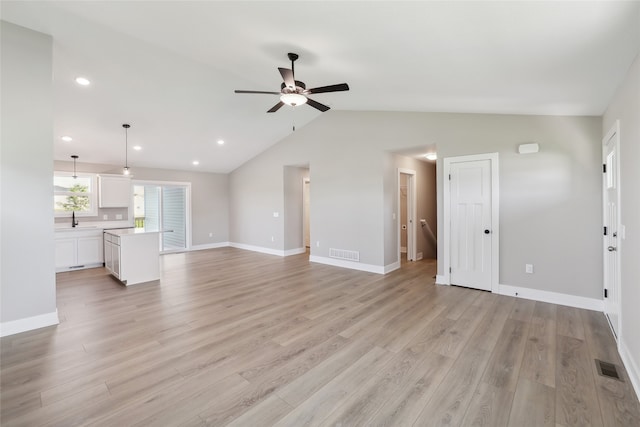 unfurnished living room featuring ceiling fan, vaulted ceiling, sink, and light hardwood / wood-style floors