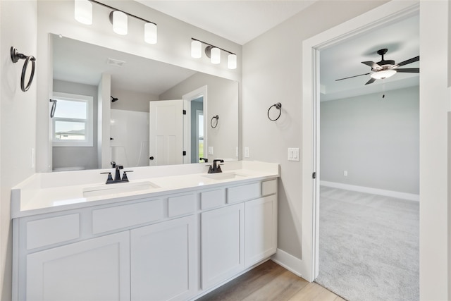 bathroom with ceiling fan, walk in shower, hardwood / wood-style flooring, and vanity