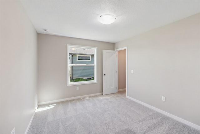 carpeted spare room with a textured ceiling