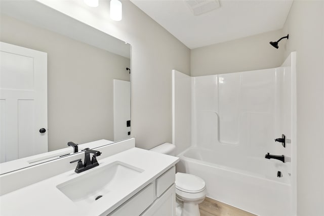 full bathroom featuring vanity, hardwood / wood-style floors, toilet, and washtub / shower combination