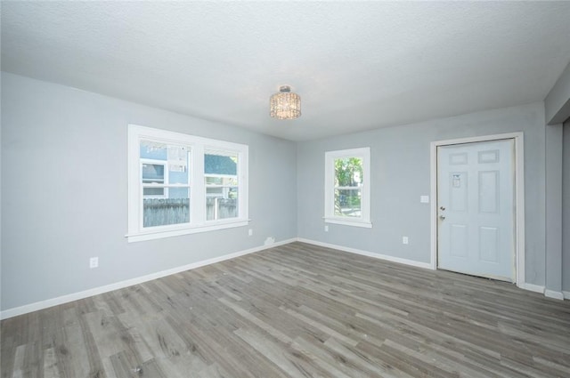 1613 York St, Des Moines, IA 50316 - unfurnished living room with wood finished floors and a textured ceiling