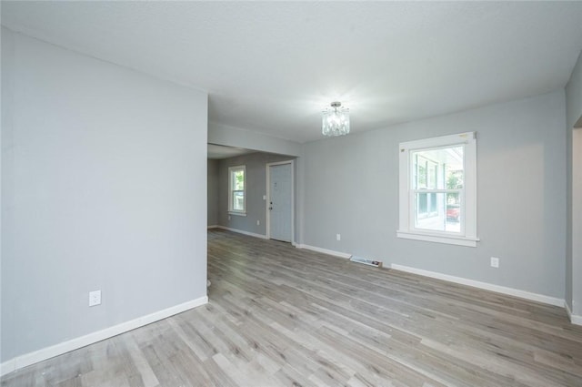 1613 York St, Des Moines, IA 50316 - unfurnished room with a chandelier and light wood finished floors