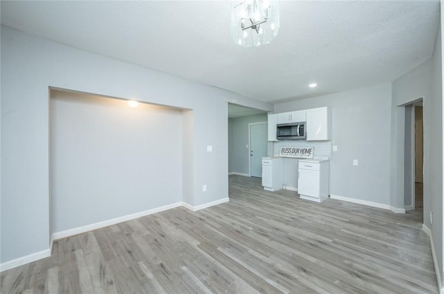 1613 York St, Des Moines, IA 50316 - unfurnished living room featuring light wood-style flooring, a chandelier, and recessed lighting