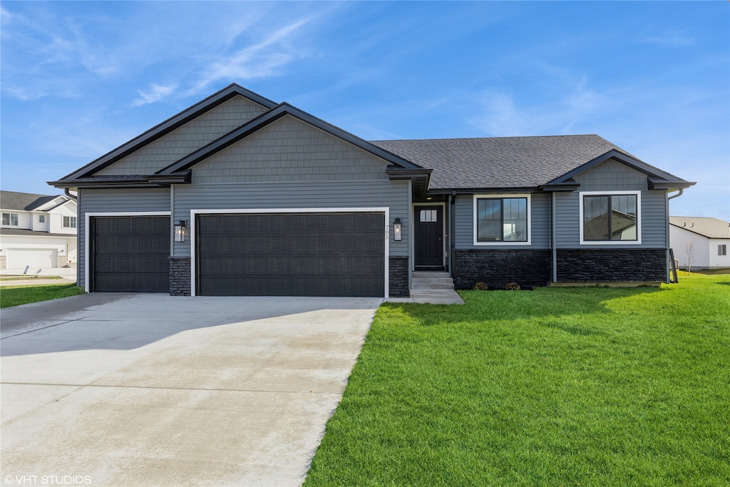 view of front of home with a garage and a front lawn