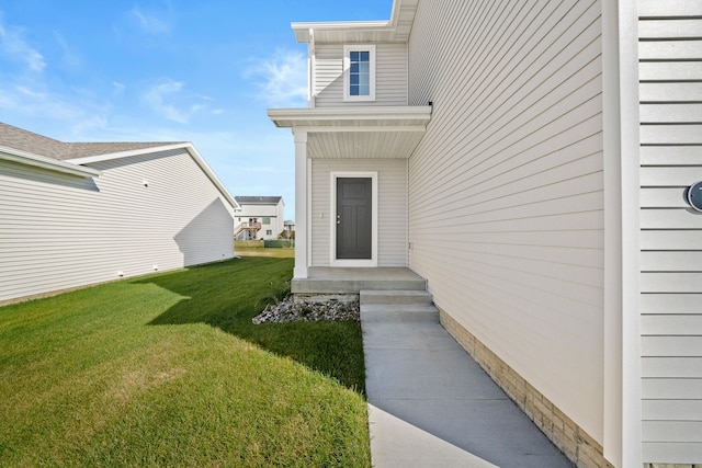 entrance to property with a lawn