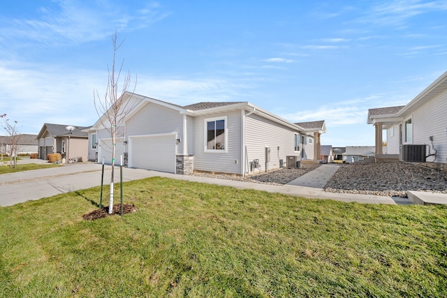 view of front facade featuring a front yard, central AC, and a garage