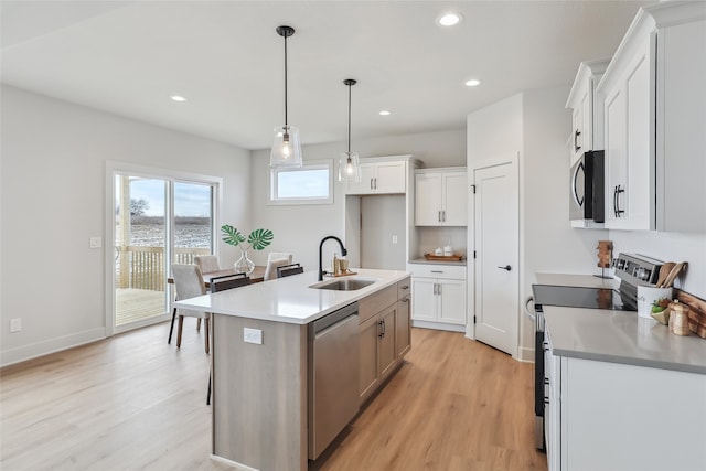 kitchen with white cabinetry, range with electric cooktop, a center island with sink, and sink