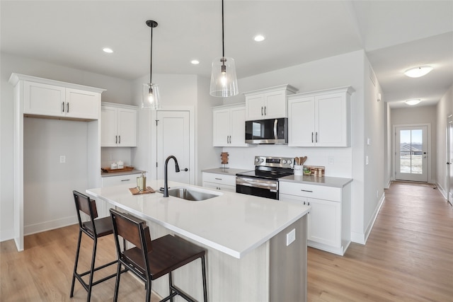 kitchen featuring white cabinets, pendant lighting, stainless steel appliances, and sink