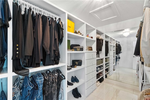 walk in closet with light tile floors