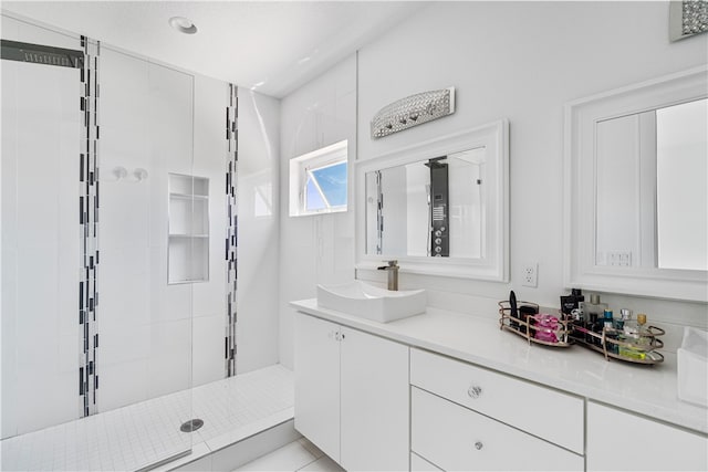 bathroom featuring a tile shower, oversized vanity, and tile floors