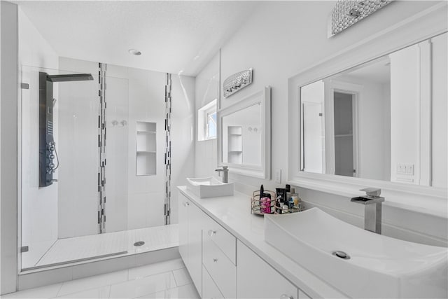 bathroom with tile flooring, an enclosed shower, dual vanity, and a textured ceiling