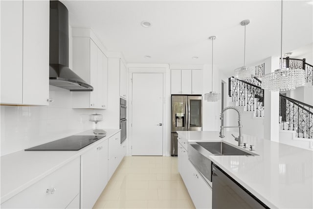 kitchen featuring wall chimney range hood, white cabinets, decorative light fixtures, and light tile floors