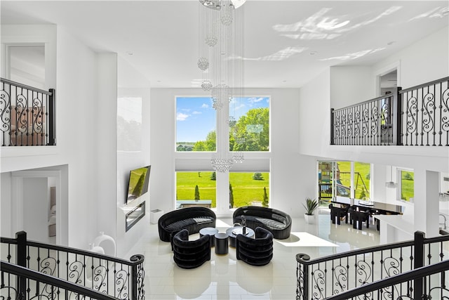 interior space with a high ceiling, tile floors, and an inviting chandelier