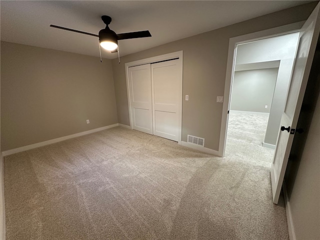 unfurnished bedroom featuring ceiling fan, a closet, and carpet