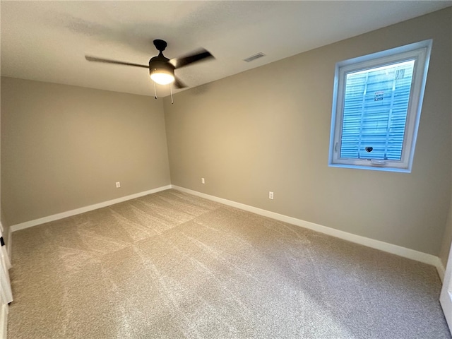 spare room featuring light carpet and ceiling fan